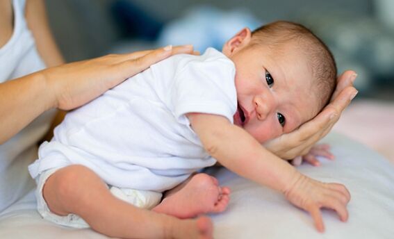 Mom patting back while holding baby in arms